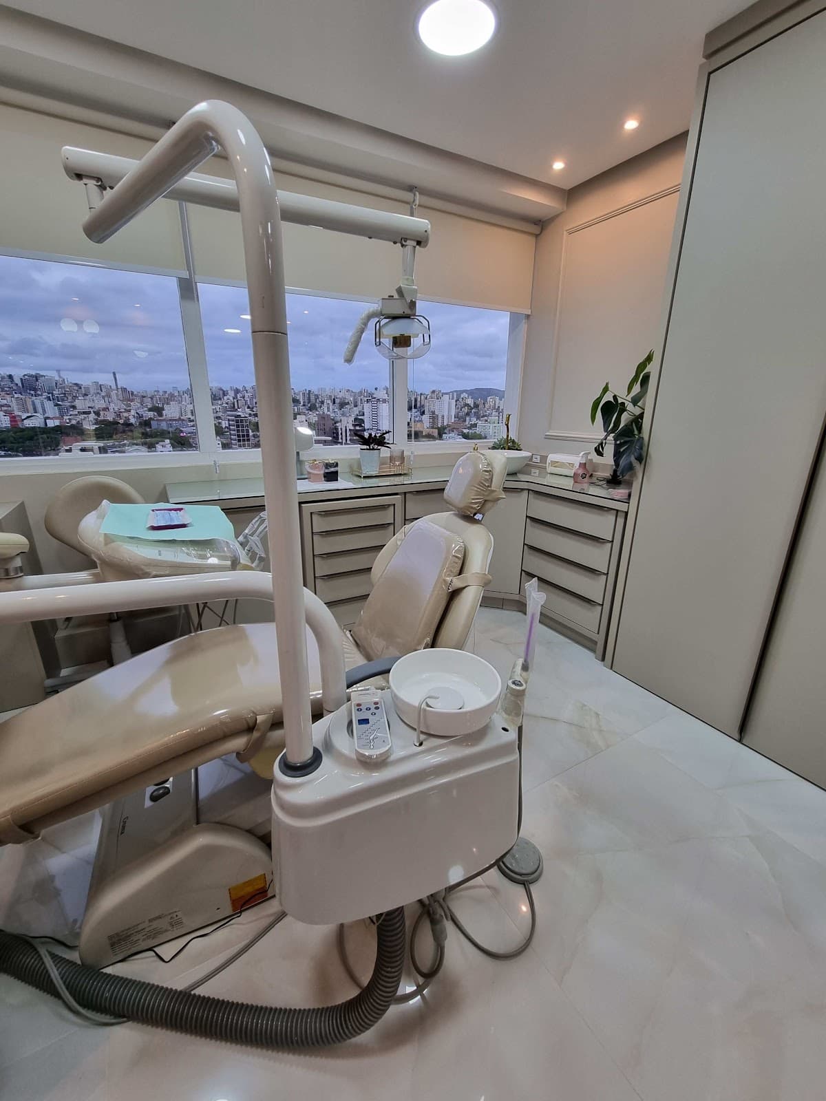 Cadeira odontológica da M.S Clinic junto à janela, com vista para a cidade